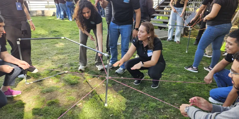 Equipo participando en dinámica de team building outdoor para fortalecer colaboración y comunicación