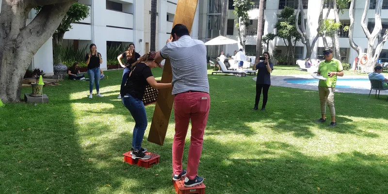 Reto de team building al aire libre para empresas con participantes colaborando en equipo