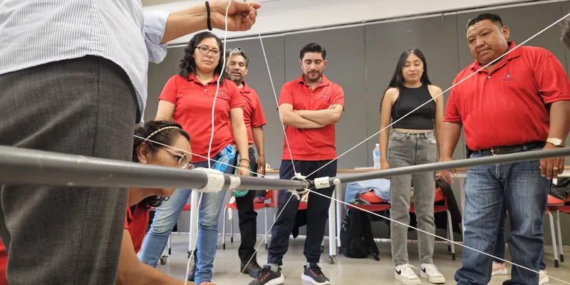 Equipo resolviendo una dinámica de colaboración en una junta de trabajo