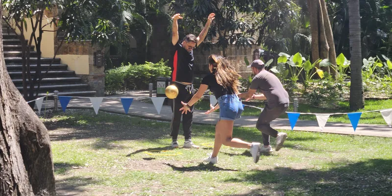 Actividad de team building outdoor en jardín con participantes resolviendo un reto de equilibrio