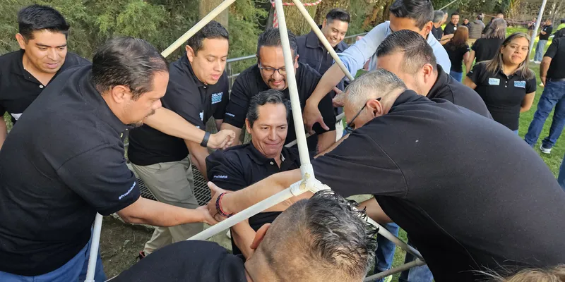 Colaboradores resolviendo una dinámica de trabajo en equipo en un team building